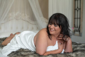 Curvy woman in white sheet boudoir session by Orlando boudoir photographer